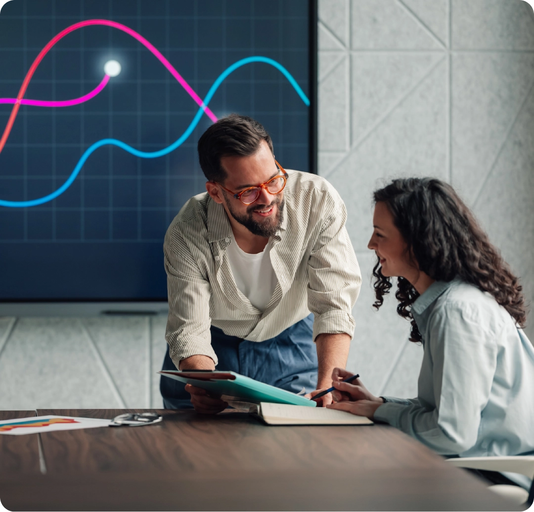 Colleagues reviewing statistics on a screen